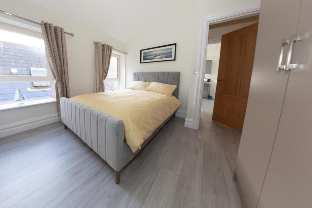 a bedroom with a bed and a window at Unit 1 Island View Apartments - Town Centre Walk To Everything in Cobh