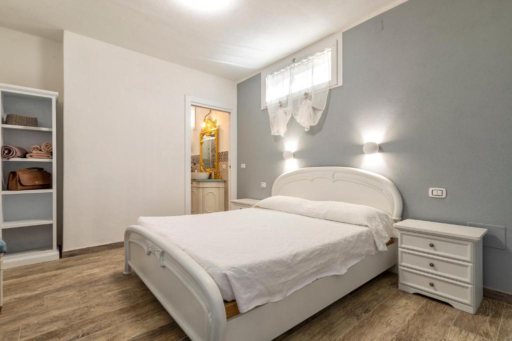 Un dormitorio blanco con una cama blanca y una ventana en Domo Minore, en Palmadula