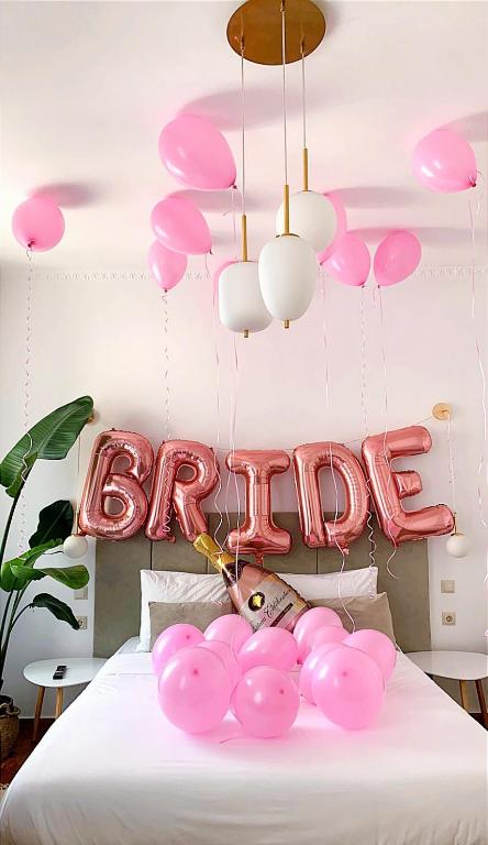 a room with a bed with pink balloons and a sign at Apeiron Acropolis Suites in Athens