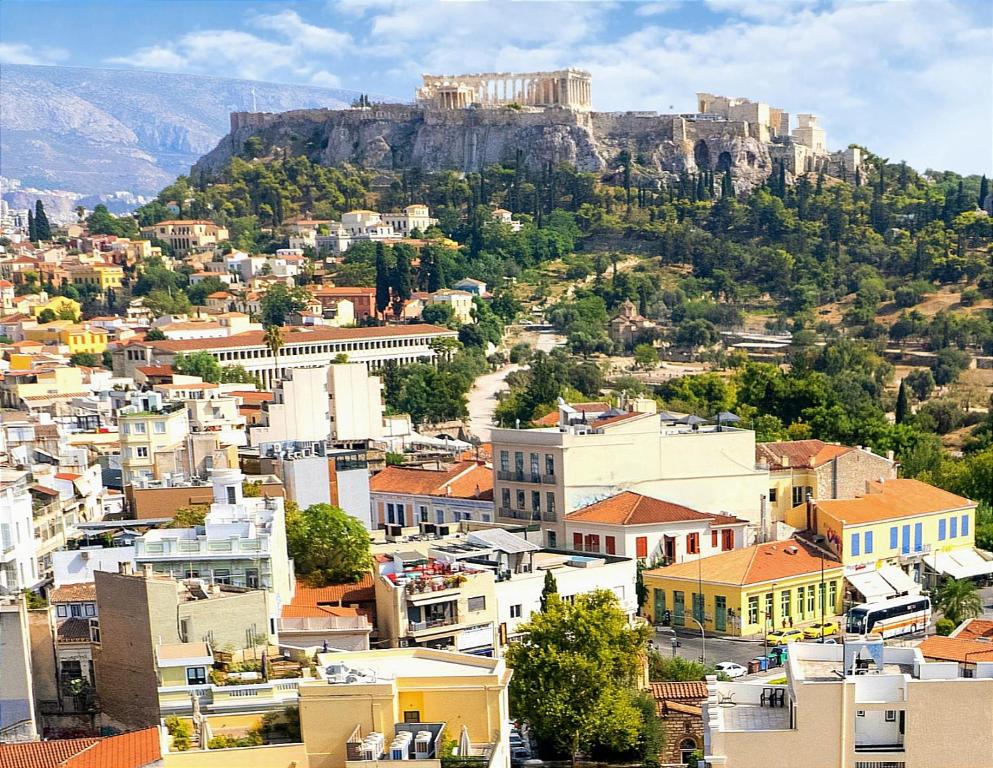 uma vista para uma cidade com uma montanha ao fundo em Apeiron Acropolis Suites em Atenas