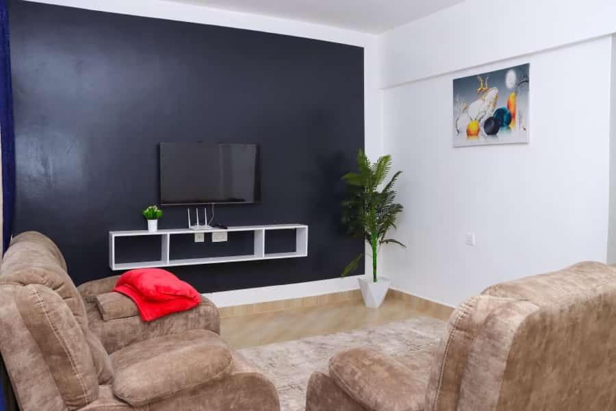 - un salon avec deux chaises et une télévision à écran plat dans l'établissement Lulu Stays 2 Bedroom, à Nyahururu
