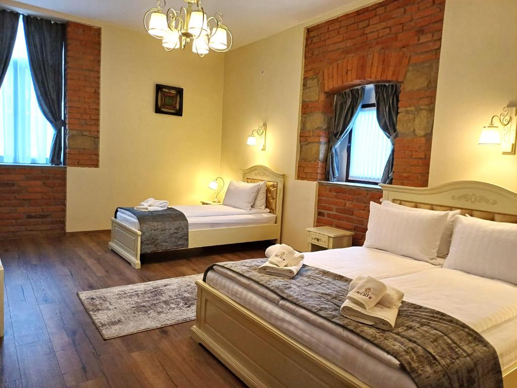 1 dormitorio con 2 camas y pared de ladrillo en Casa Huber en Sighetu Marmaţiei