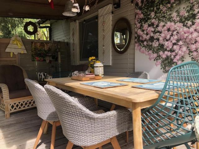 - une table en bois avec des chaises sur la terrasse dans l'établissement Chalet Luxe, à Zutendaal