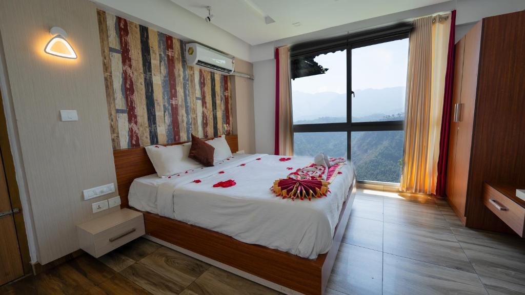 sypialnia z dużym łóżkiem i dużym oknem w obiekcie Hilton Cloud Resort w mieście Wayanad
