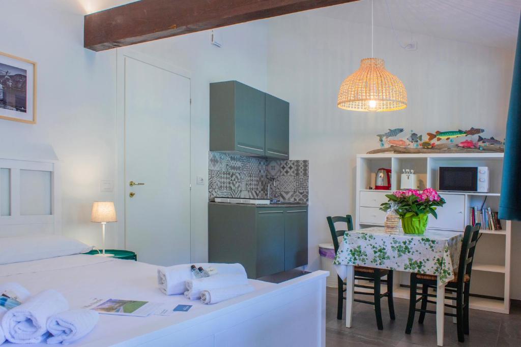 een kamer met een bed, een tafel en een keuken bij Villa Onedo in Abbadia Lariana