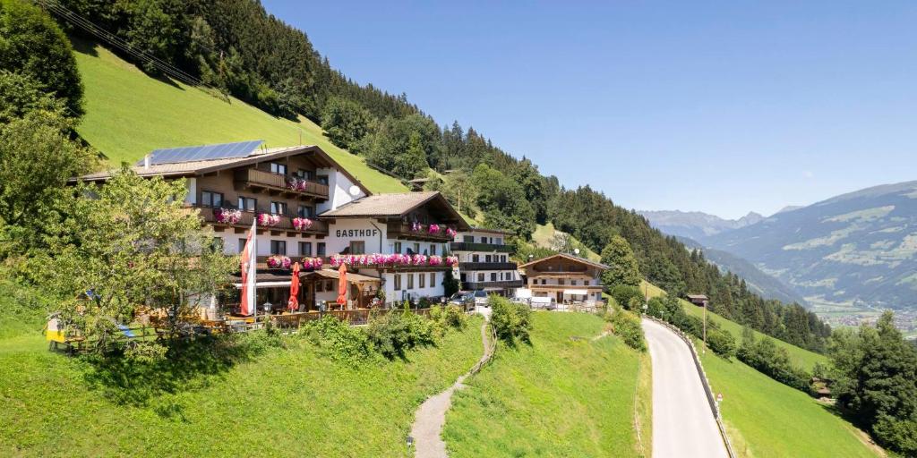 un edificio su una collina vicino a una strada di Gasthof Pension Berghof a Hippach