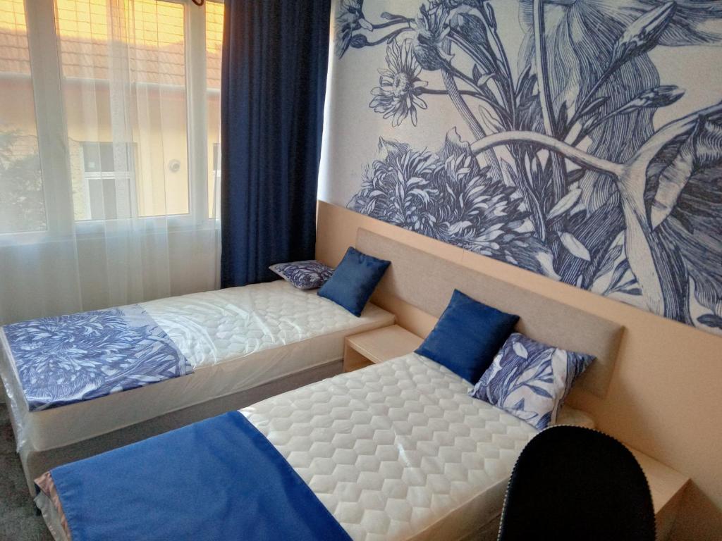 1 dormitorio con 2 camas y un cuadro en la pared en Hotel Merlot en Eger