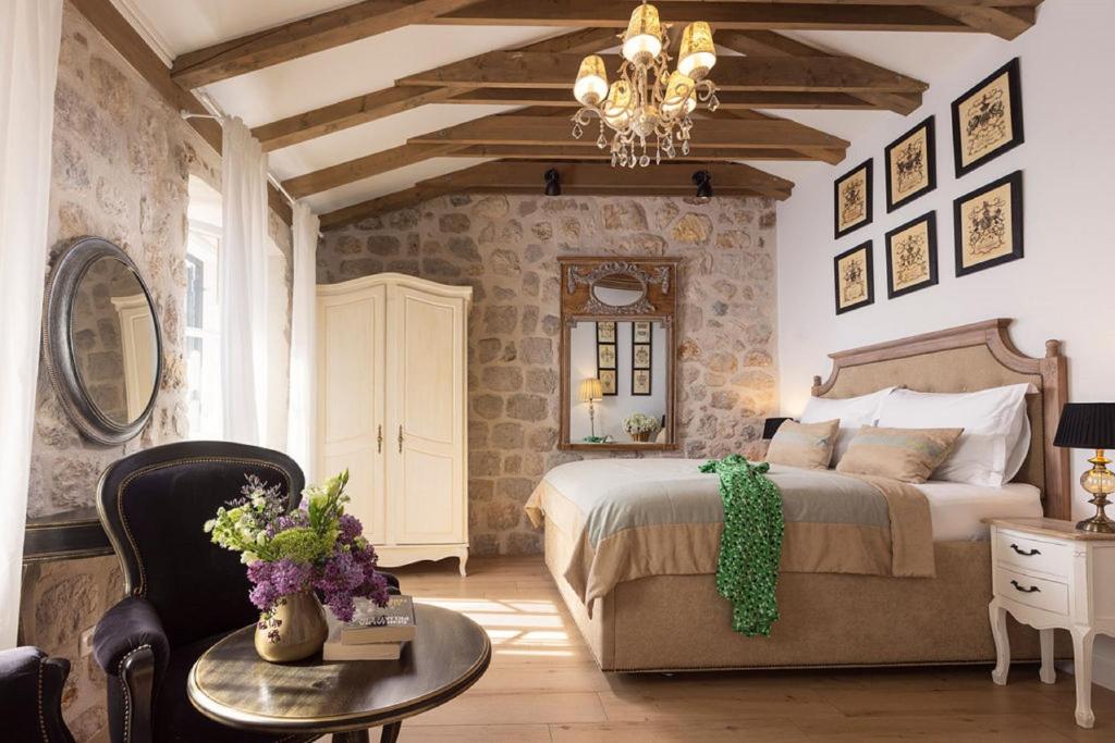 1 dormitorio con cama, mesa y lámpara de araña en Vivaldi en Dubrovnik