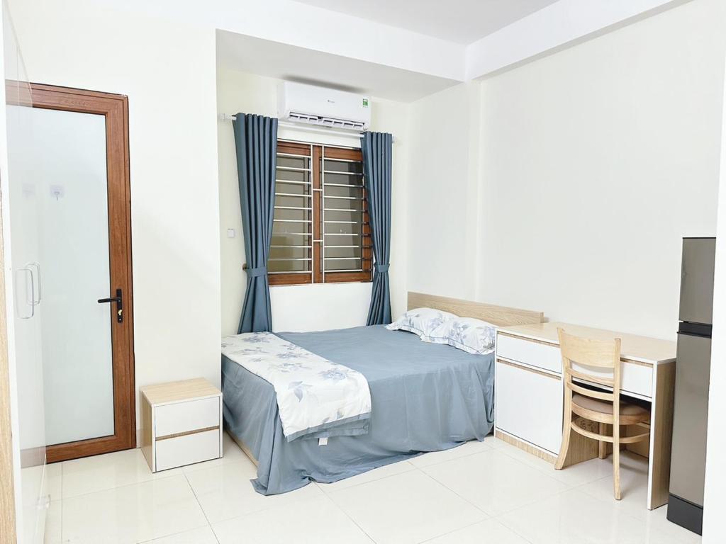 um quarto com uma cama, uma secretária e uma janela em nha7bngo140tdh em Hanói