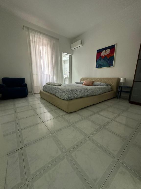 a bedroom with a bed and a tiled floor at Joy Guest House in Torre del Greco