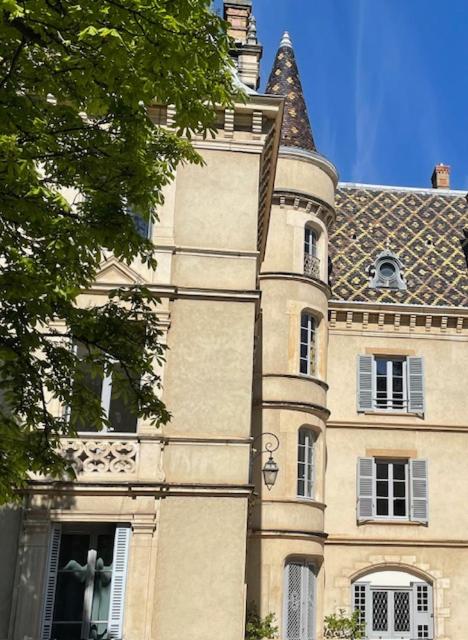 un grand bâtiment avec une statue sur le côté dans l'établissement Grand appartement d'exception au Château Randin, à Écully