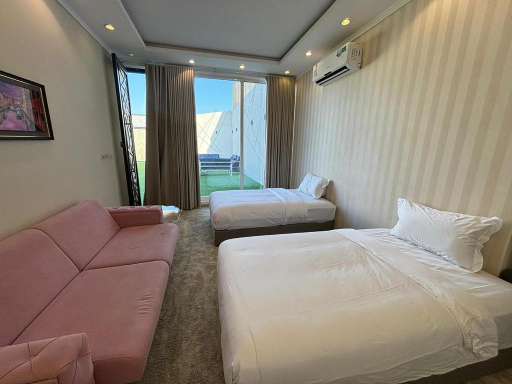 una camera d'albergo con due letti e un divano di ريزا a Medina