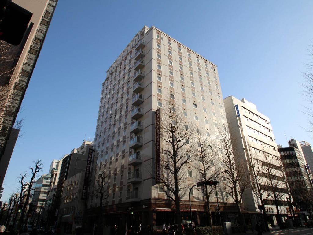a tall building in a city with tall buildings at APA Hotel Yokohama Kannai in Yokohama