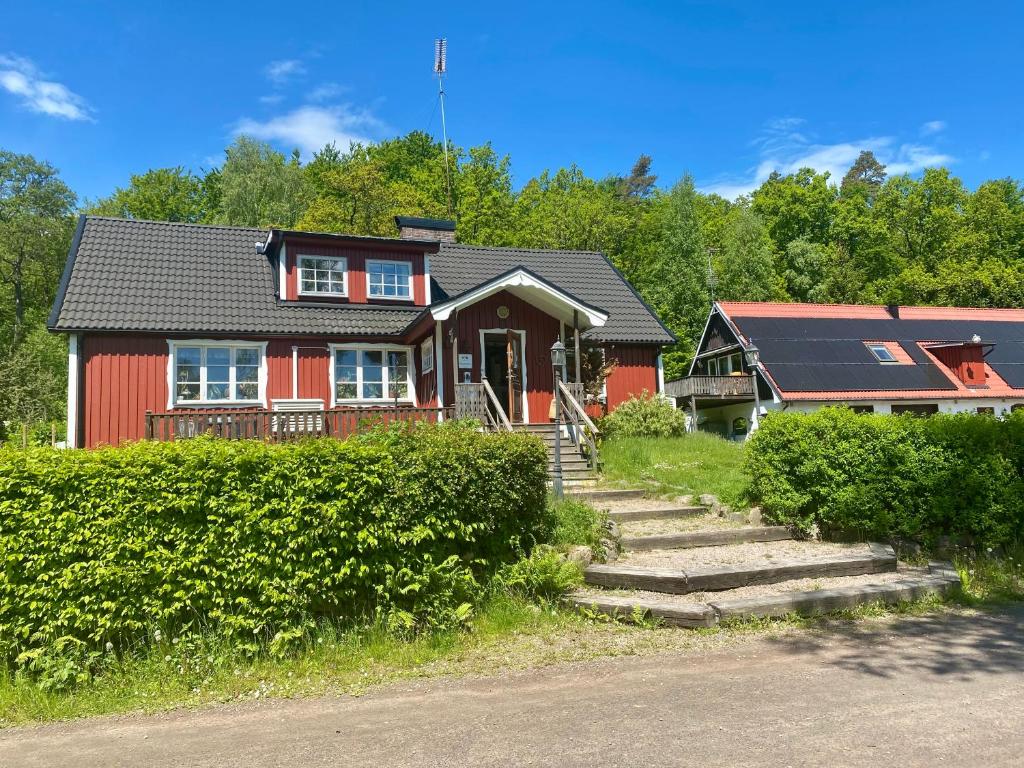 une maison rouge avec un toit noir dans l'établissement Ullstorps Stugor, à Höör