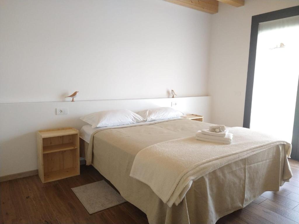 a white bedroom with a bed and a table at Agriturismo Verdecielo in Padova
