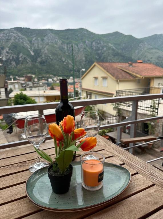 un plato con una botella de vino y flores en una mesa en Club Themis Hotel en Kotor