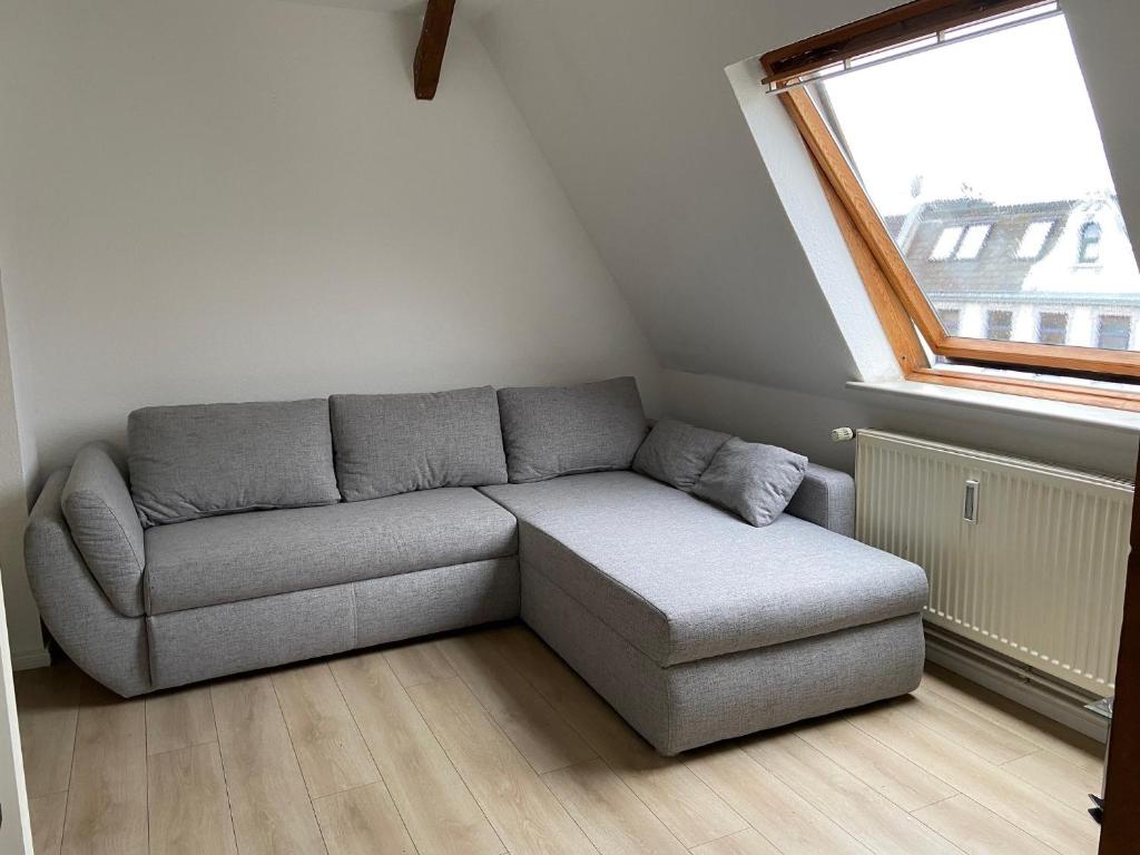 a living room with a couch and a window at Komfortabele Ferienwohnungen mitten im Zentrum Bremerhavens in Bremerhaven