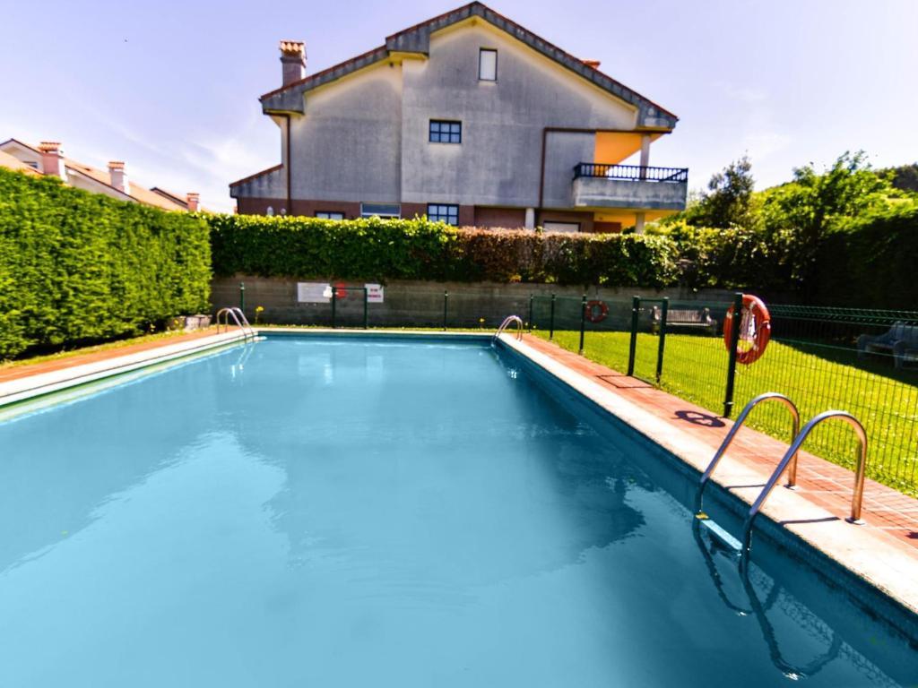 een zwembad voor een huis bij Cómodo y espacioso chalet con piscina comunitaria in Miengo