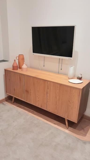 un téléviseur à écran plat posé sur un meuble en bois dans l'établissement Jolie Duplex Quai de la Joliette, à Marseille