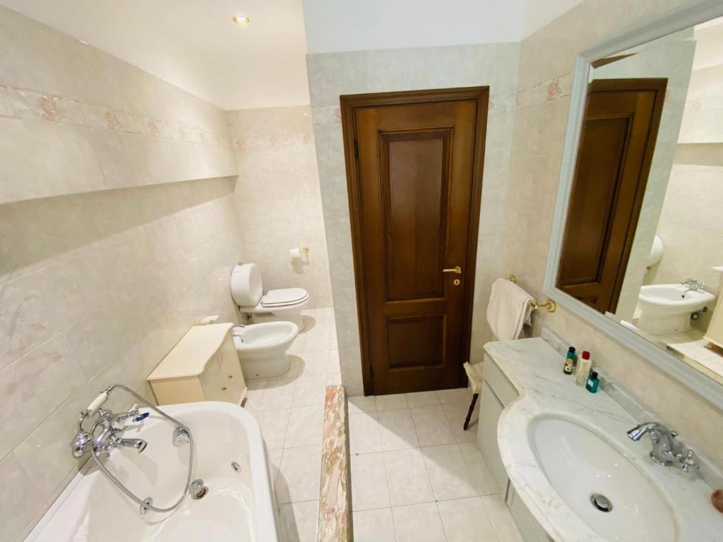 een badkamer met een bad, een wastafel en een toilet bij Comfortable apartment in tuscan wine farm in Montecarlo