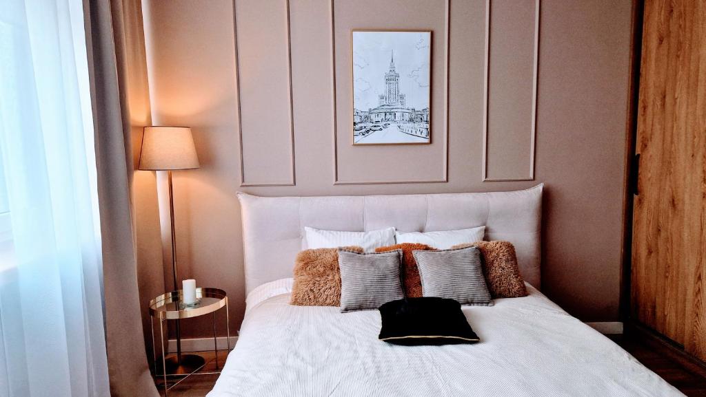 sypialnia z białym łóżkiem z poduszkami w obiekcie Atlas Design Apartment 2X w Warszawie