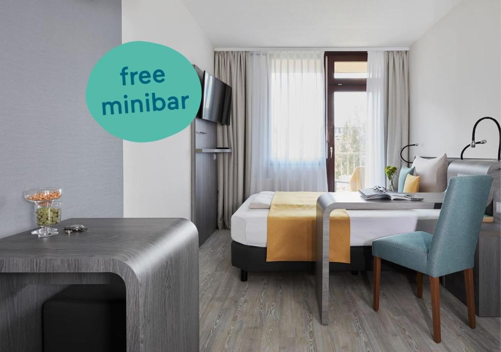 a hotel room with a bed and a desk with a sign free multimedia at Living Hotel am Deutschen Museum in Munich