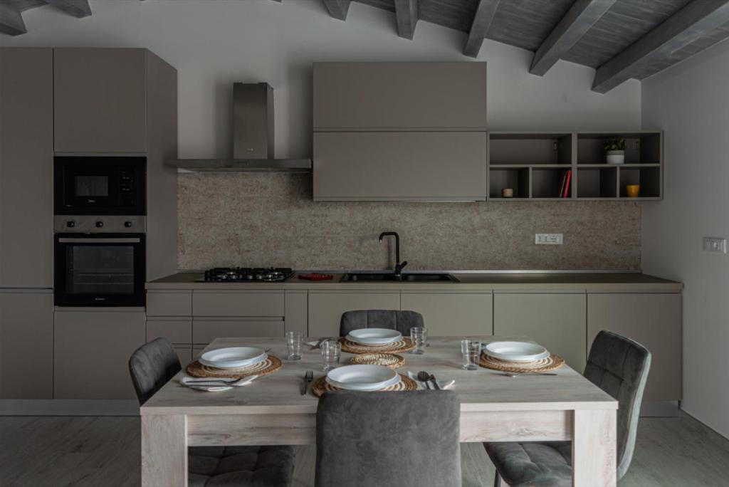 a kitchen with a wooden table with chairs and a tableasteryasteryasteryasteryastery at A cara a mare in Posada