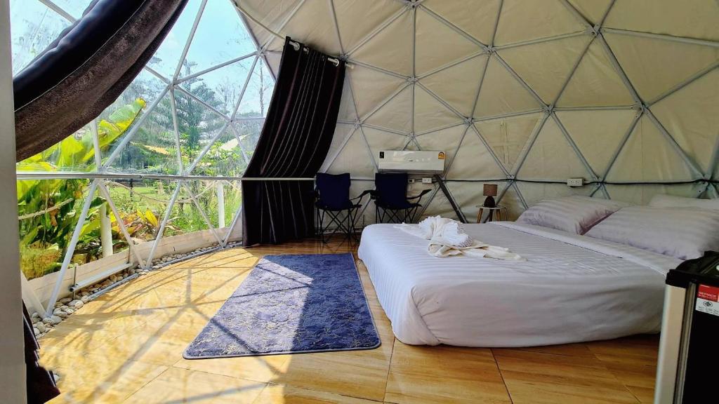 Habitación con cama en una tienda de campaña en la cúpula en Greatland Glamping Khao Yai Resort, en Ban Khanong Phra Tai