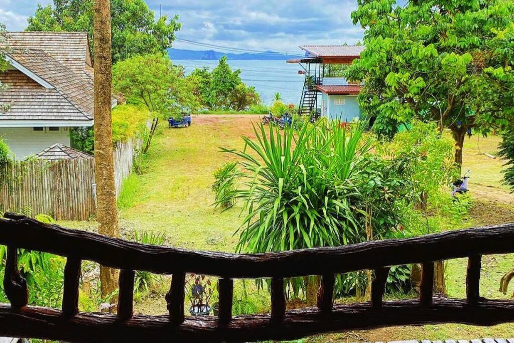 una vista da una panca di legno che si affaccia su un cortile di Yao Noi Island, Sea view house, 2 min to beach. a Ban Laem Sai