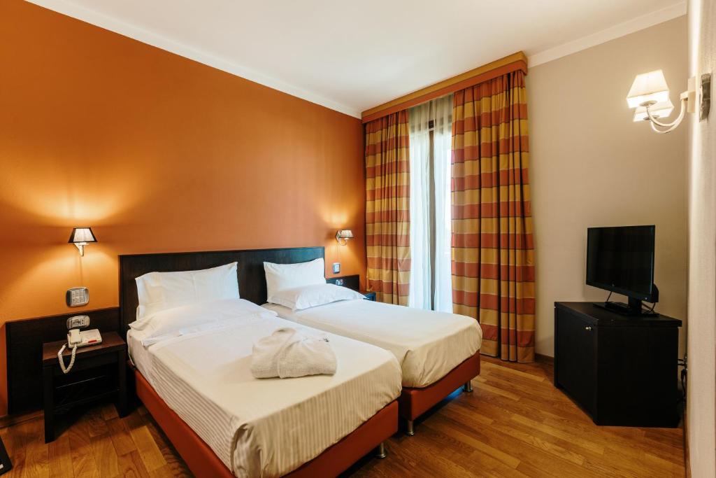 Cette chambre comprend deux lits et une télévision. dans l'établissement Hotel Dei Vicari, à Scarperia