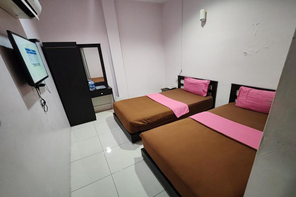 Postel nebo postele na pokoji v ubytování Hotel Kuang Hua Sitiawan Near To UniKL-MIMET