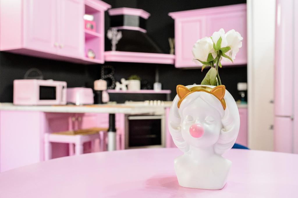 a pink kitchen with a vase with a flower in it at PINK HOUSE TORTELLINOSUITE Modena in Modena