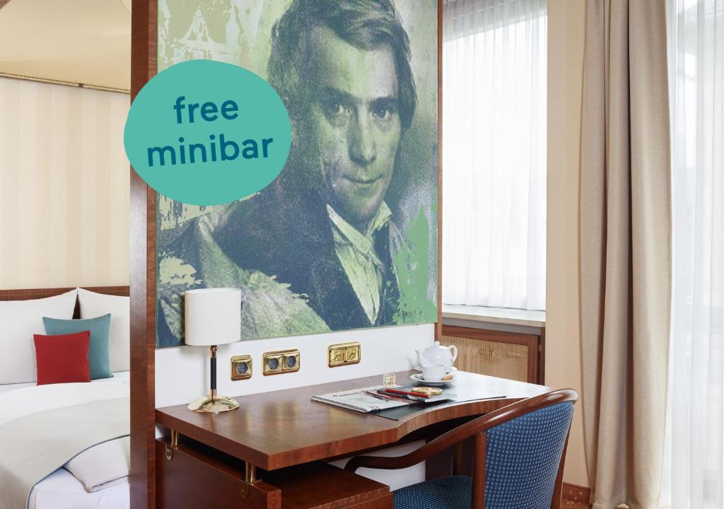 a hotel room with a desk with a poster of a man at Living Hotel Kanzler in Bonn
