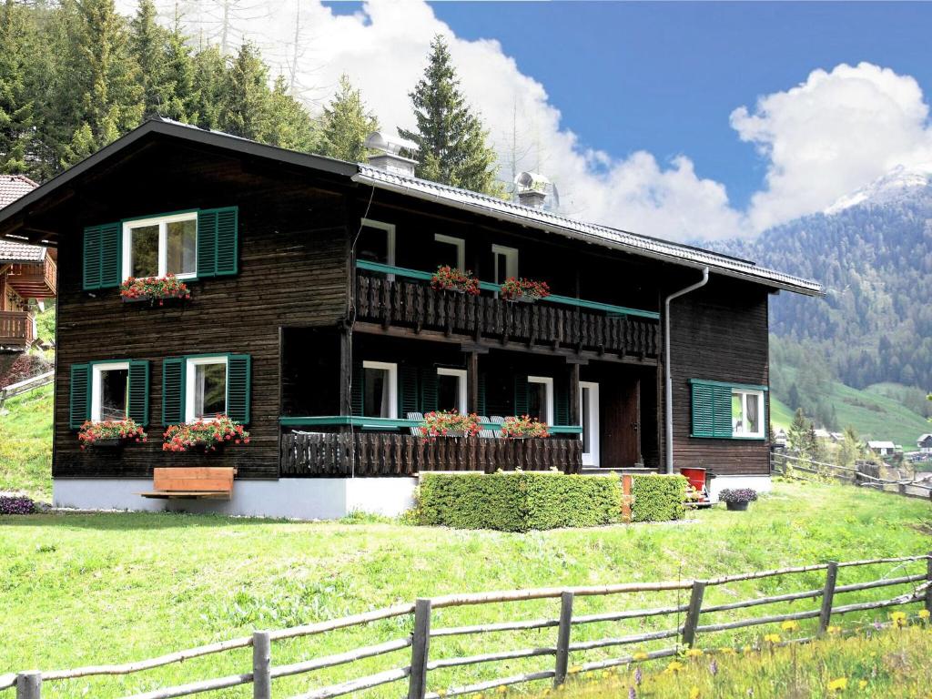 Beautiful and very luxurious chalet in walking and skiing area Innerkrems في ان كارنتين: منزل على تلة مع سياج أمامه