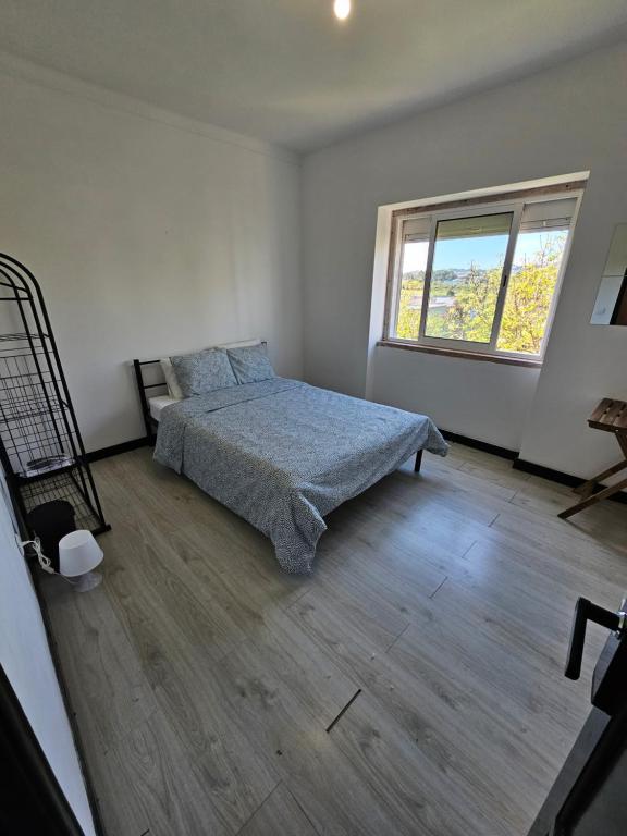 una camera con letto e finestra di ALDEIAS DE SINTRA a Terrugem