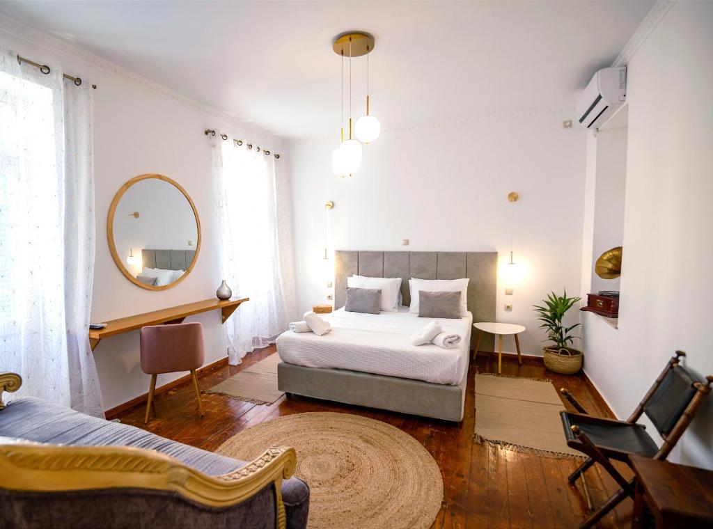een slaapkamer met een groot bed en een spiegel bij Apeiron Acropolis Suites in Athene