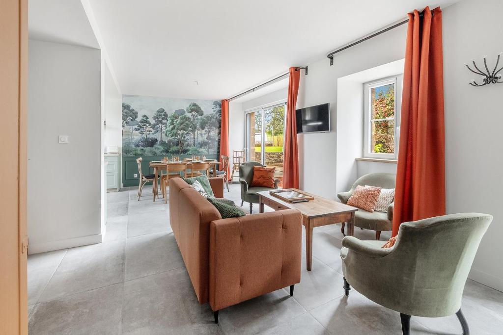 een woonkamer met een bank en een tafel bij LA BAIE - Belle maison de charme -Jardin/Parking in Cancale