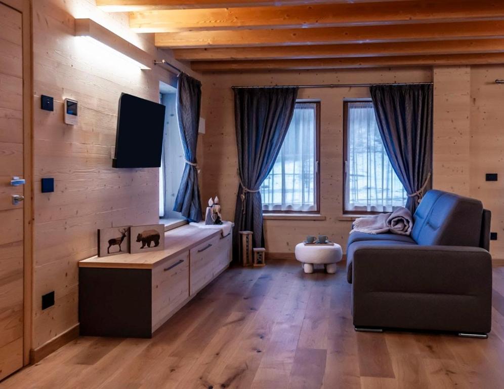 a large living room with a couch and a tv at Antico Borgo Palue in Sottoguda