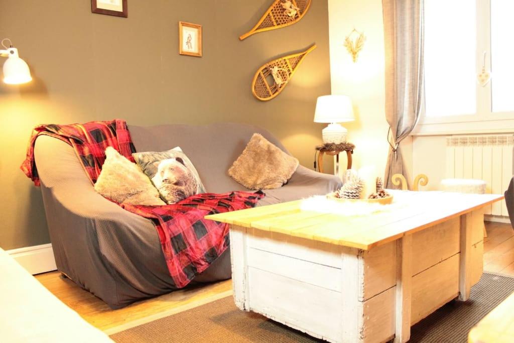 ein Wohnzimmer mit einem Sofa und einem Tisch in der Unterkunft L'Aparté - Cosy corner in Bussang