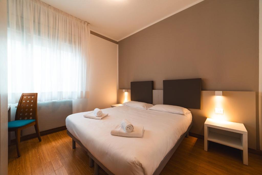 een slaapkamer met een bed met twee handdoeken erop bij Hotel Del Corso in Bibione