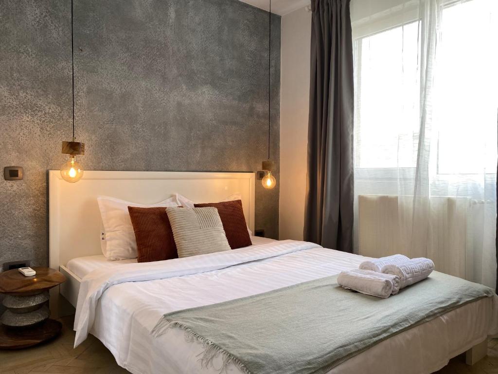 a bedroom with a large bed with two towels on it at Old Town Overlooking - Vibrant 2BR Apartment in Bucharest