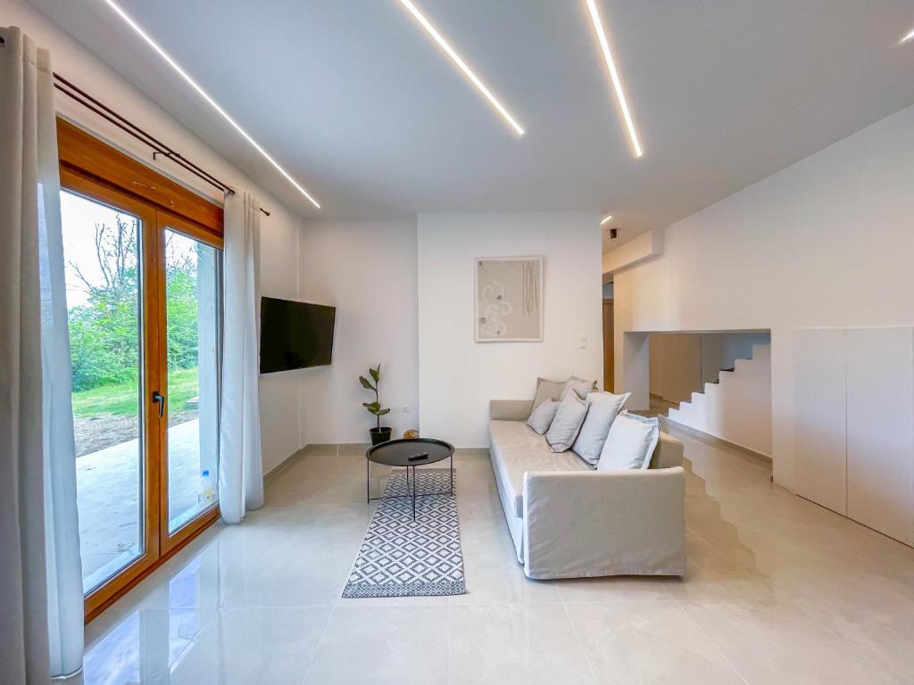 a living room with a white couch and a tv at Oasis Acropolis Serres Next to Center in Serres