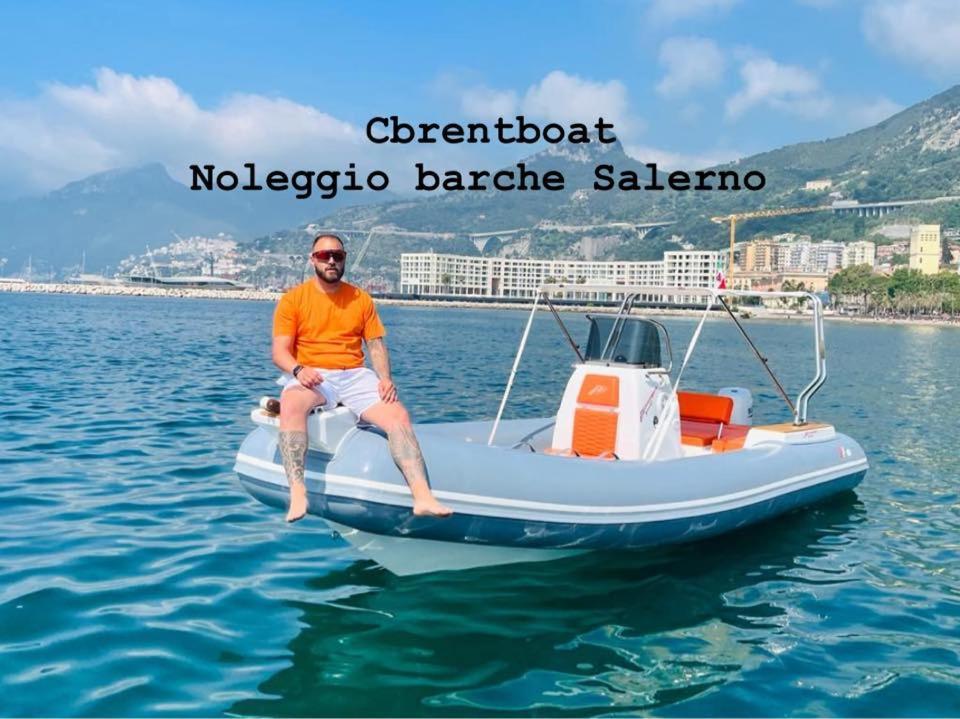 a man sitting on a boat in the water at Cbrentboatsalerno in Salerno