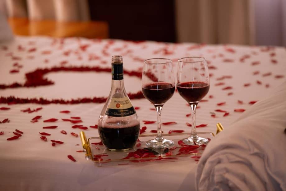a bottle of wine and two wine glasses on a table at Boloti Camp resort in Lemira