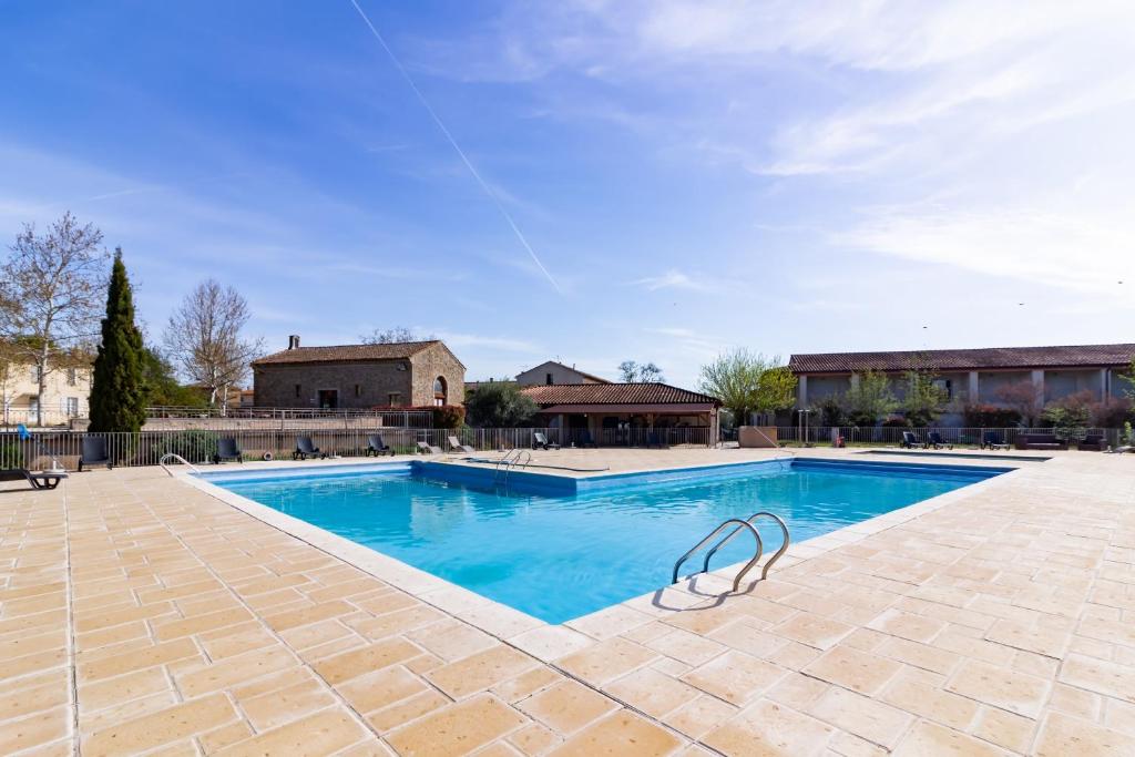 uma grande piscina com água azul em Le Jouarres - Appt climatisé avec piscine partagée em Azille