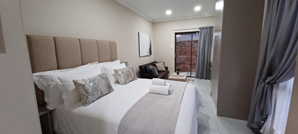 金伯利的住宿－Hub Accomodation，卧室配有带枕头的白色床和窗户。