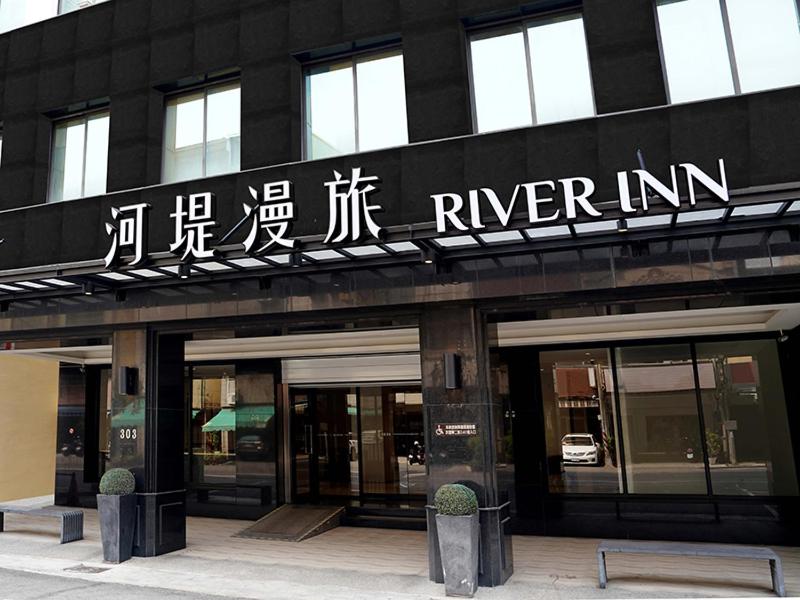a black building with writing on the side of it at River inn Zili in Kaohsiung