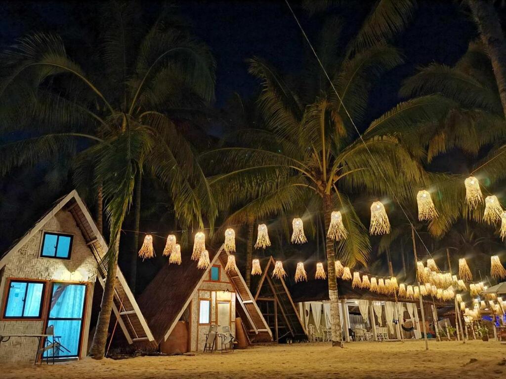 ein Haus am Strand mit Palmen in der Nacht in der Unterkunft casa lovena by the sea in Lianga
