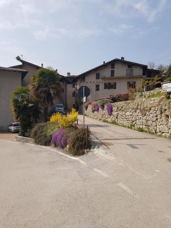 een straat met een stopbord en wat bloemen bij Mansarda Dolomitica in Ronzo Chienis