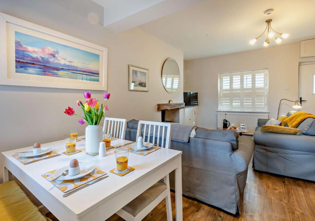 a living room with a table and a couch at Quay View Cottage in Wells next the Sea